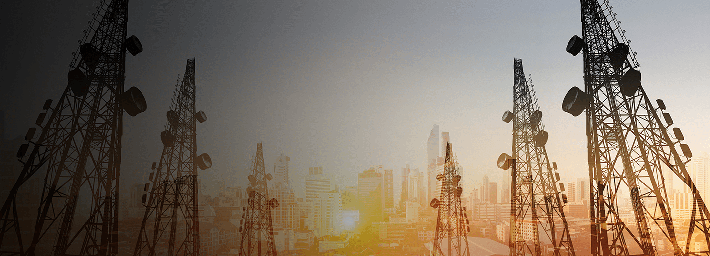 telecommunication towers with TV antennas and satellite dish in sunset, with double exposure city in sunrise background