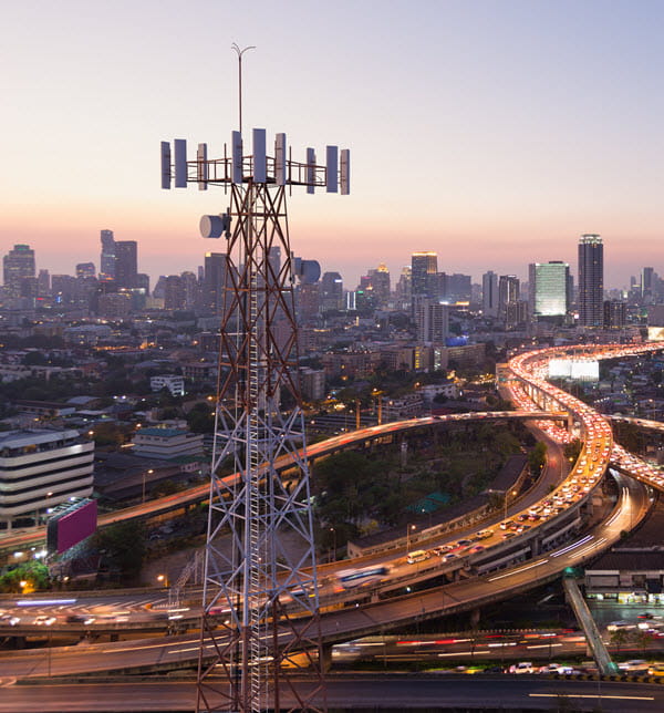 Telecommunication tower with 5G cellular network antenna on city background