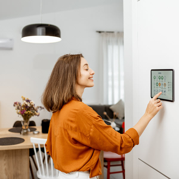 Woman controlling home devices using a wall-mounted screen